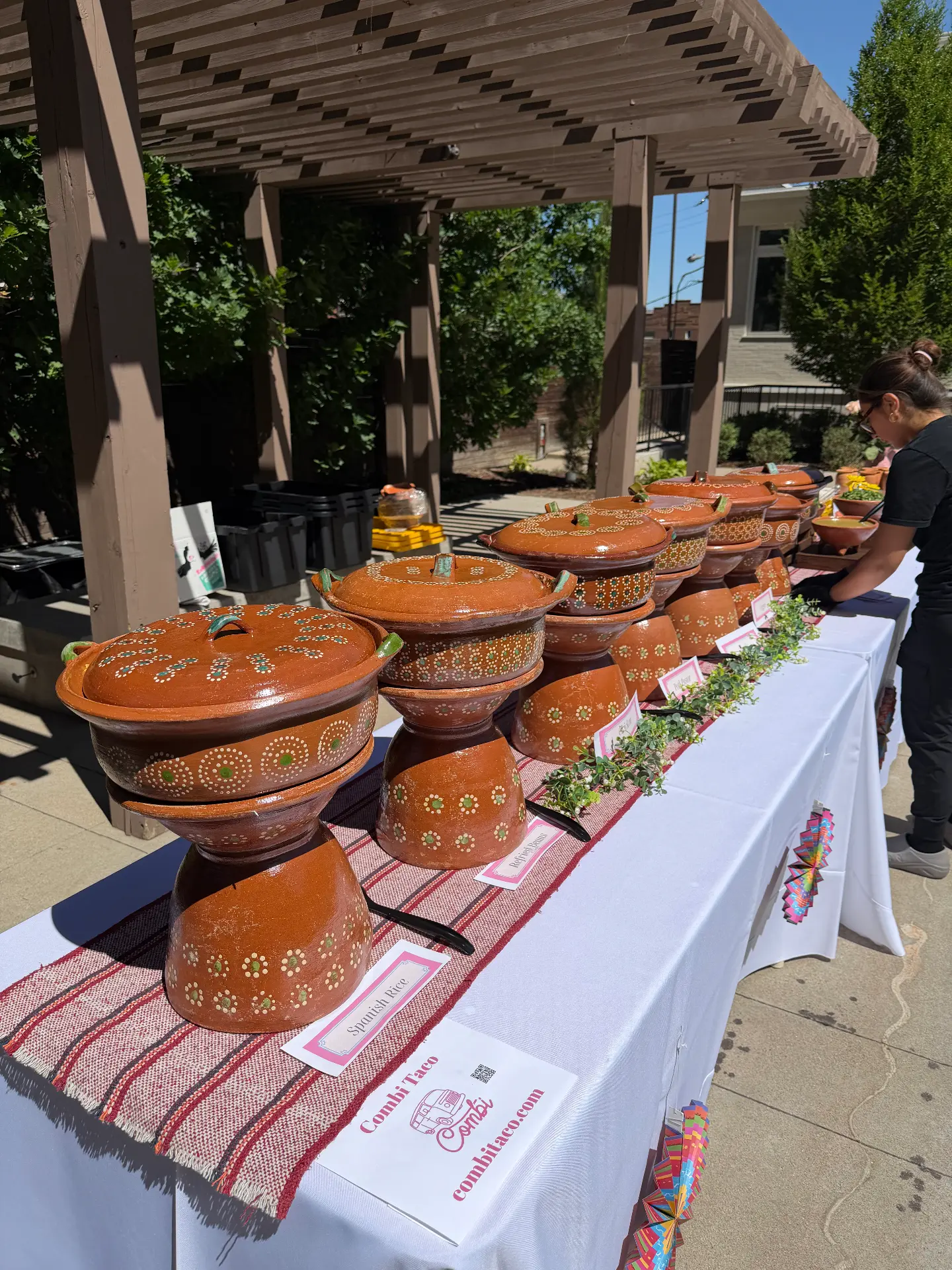 Outdoor clay pot taco bar setup under a pergola